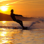 Silouhette of a young tall boy wakeboarding at French Riviera against the sunset.